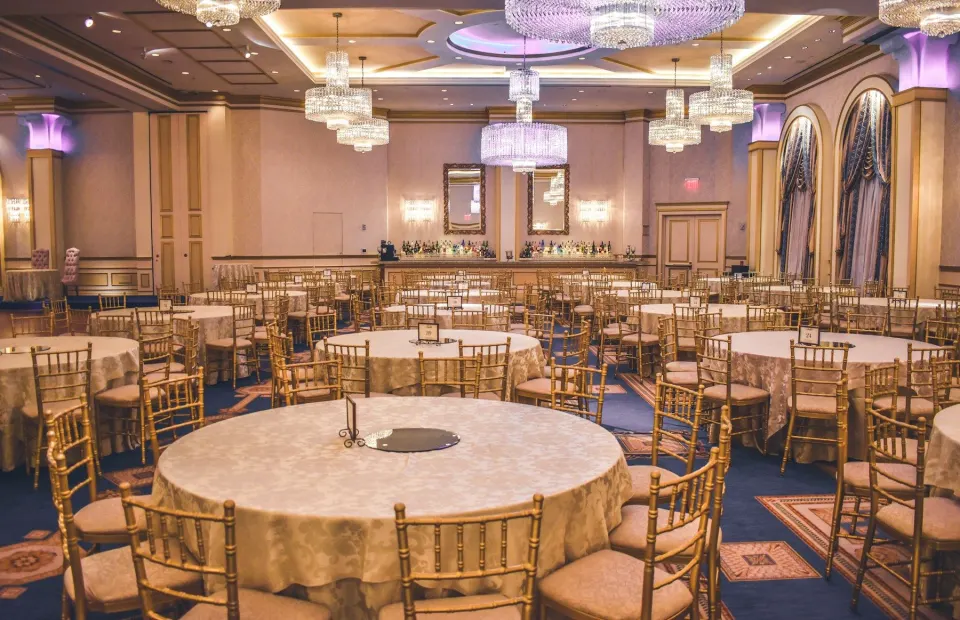 Sală decorată pentru un eveniment, cu mese rotunde