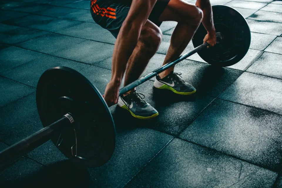 Sportiv care ridică o haltă, prim-plan pe mâini și bară