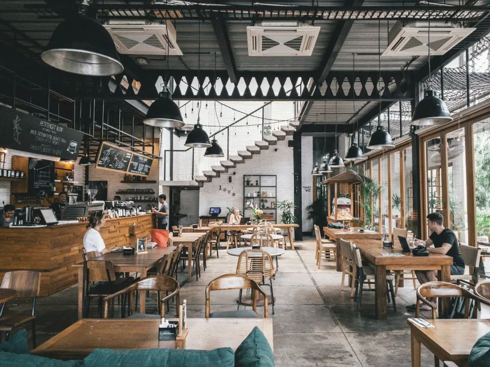 Zonă de food hall luminoasă și deschisă, cu mese